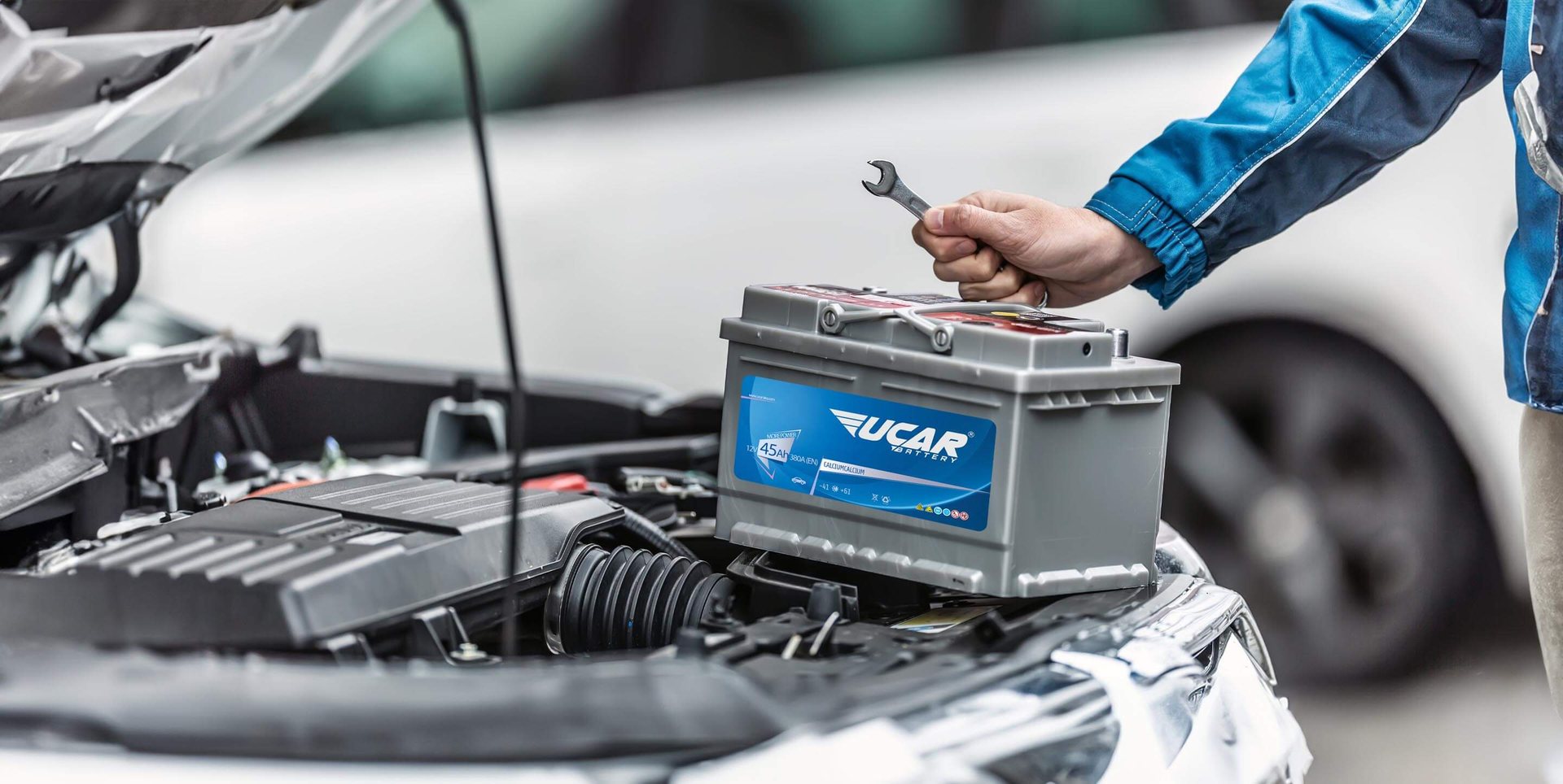 Uçar Akü battery being fitted in a vehicle engine bay